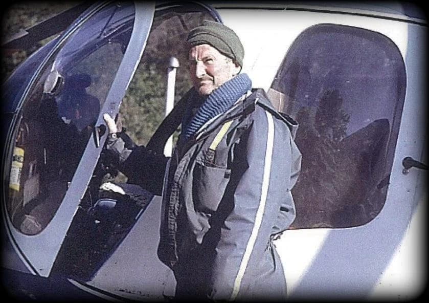 Alan Duncan beside a helicopter.