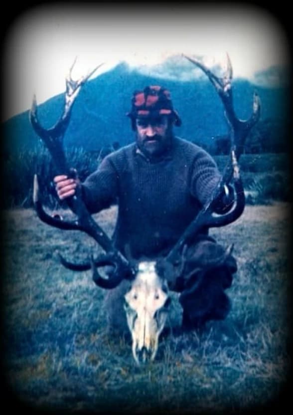 Bob Gibson holding a deer head while hunting.